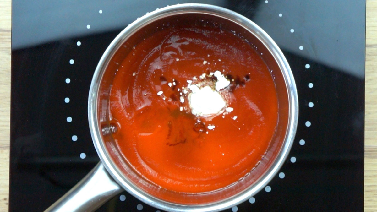 Small pot with red sauce, spices and white powder. 