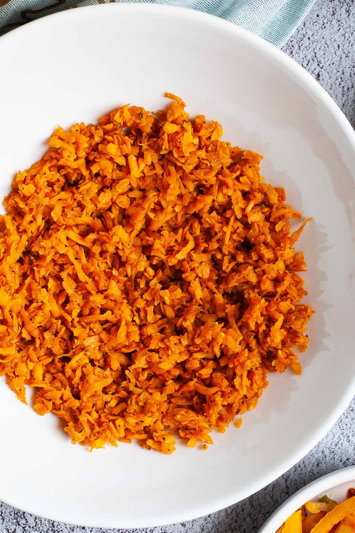A large white plate in the middle orange riced sweet potato.