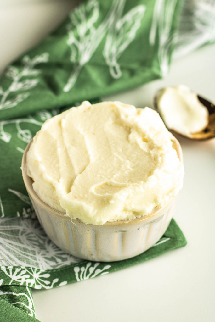 A bowl of Lebanese Toum, a luscious garlic dip, with a spoon next to it.