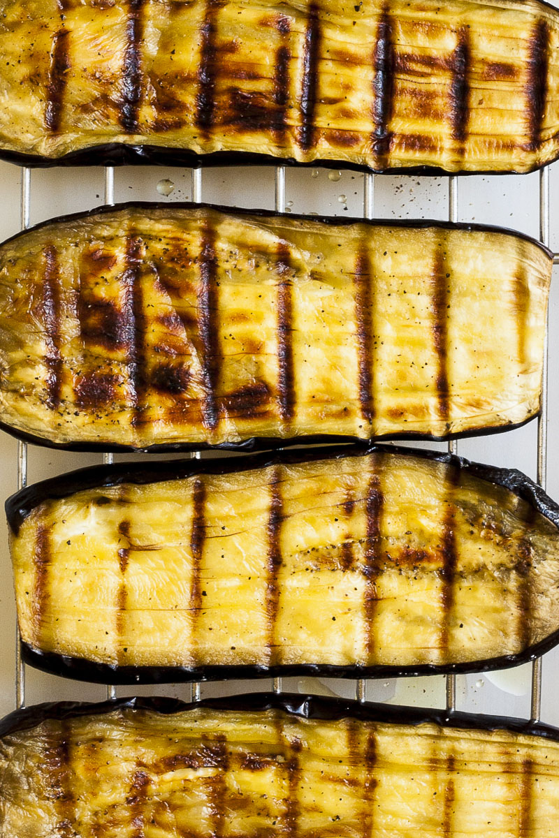 Eggplant slices slightly browned with dark brown lines due to the grill rack it was roasted on. 