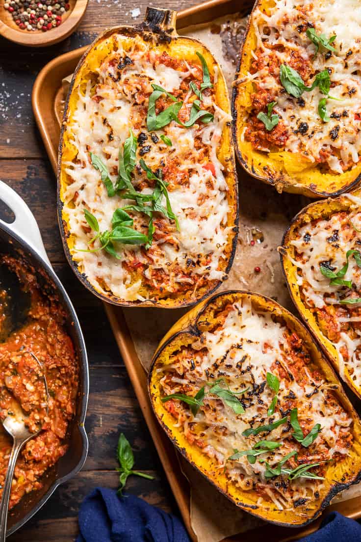 Vegan meat stuffed spaghetti squash on a baking tray.
