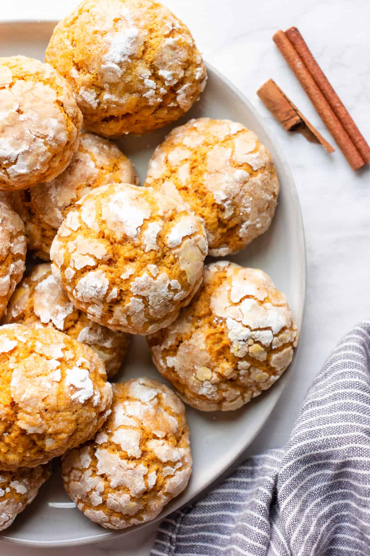 Vegan pumpkin crinkle cookies on a plate on a white background.