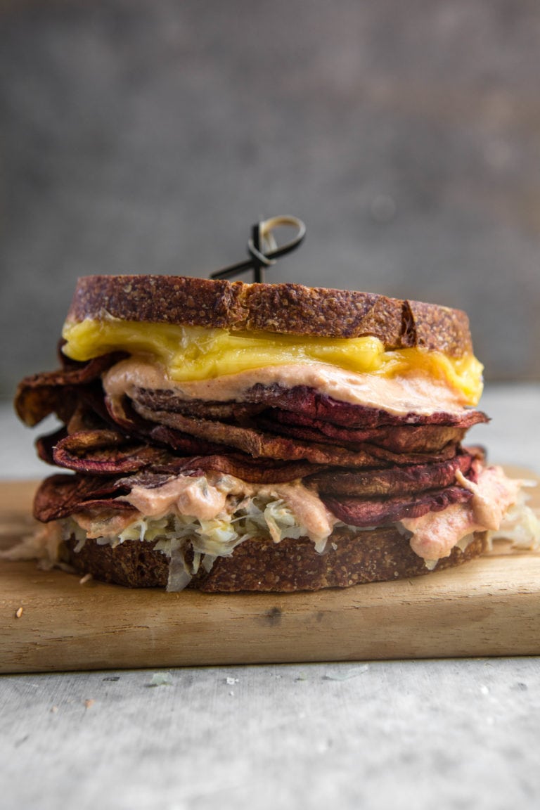 vegan eggplant reuben on wood cutting board.
