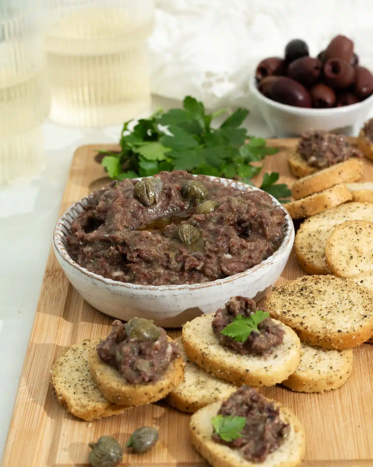 Eggplant tapenade in a bowl and on some crostini ready to eat. 
