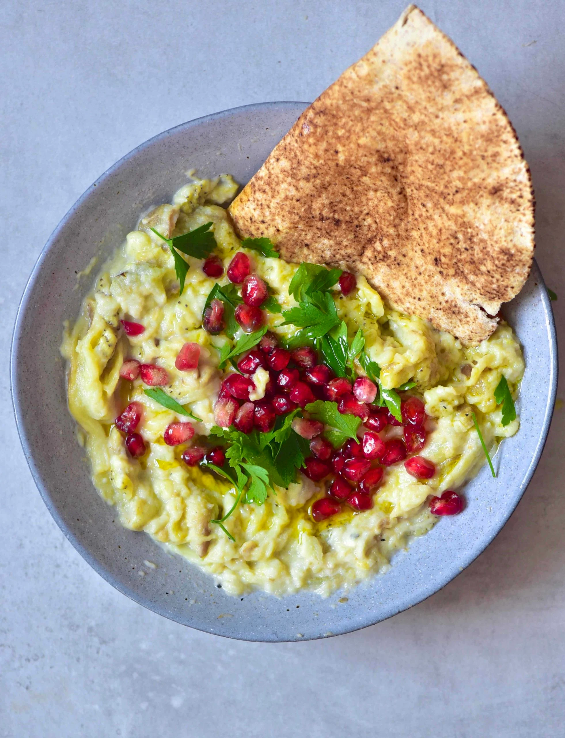 Simple Smoky Eggplant Dip ( Moutabal) in a bowl with pita bread.
